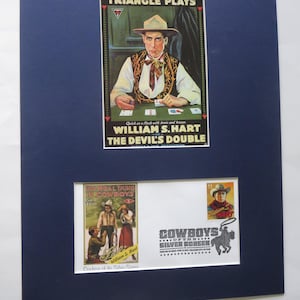 May include: Framed vintage movie posters featuring William S. Hart. The main poster is for "The Devil's Double," with Hart in a cowboy outfit. Additional elements include a stamp and a smaller poster, all set against a navy blue mat.