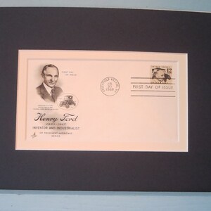 May include: A framed first day of issue envelope featuring a black and white portrait of Henry Ford, inventor and industrialist. The envelope has a 12-cent stamp with a black and white image of a Model T car. The envelope is dated 30 July 1968.