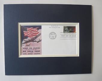 May include: A first day of issue envelope for a 29-cent stamp commemorating World War II. The envelope features a vintage illustration of a B-24 bomber flying over a waving American flag with the text "Keep 'em Flying - Do Your Part for Duty - Honor - Country".
