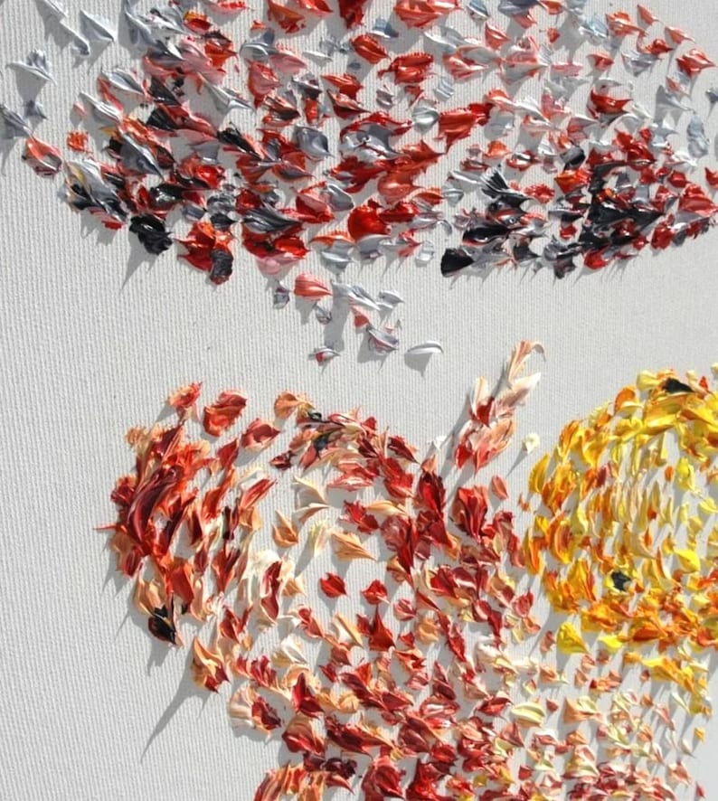 May include: Close-up of an abstract painting on a white canvas. The artwork features textured brushstrokes in shades of red, orange, yellow, silver, and black. The painting's composition is suggestive of a heart shape.