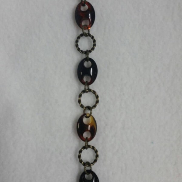 A bracelet done it amber marble brown and antique gold links