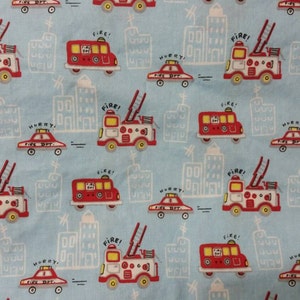 A light blue pillowcase with red and white rescue vehicles