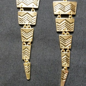 Gold triangler dangle earrings with black chevron stripes