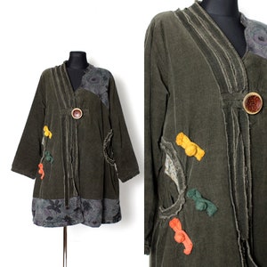 May include: A dark green corduroy jacket with a V-neck and decorative buttons. The jacket has a patchwork design with floral fabric and colourful accents.