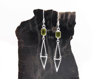 Puede incluir: Pendientes de plata con una piedra preciosa verde y un colgante triangular.