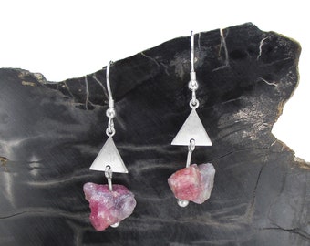 May include: Silver dangle earrings with a triangular charm and a pink and white gemstone pendant.