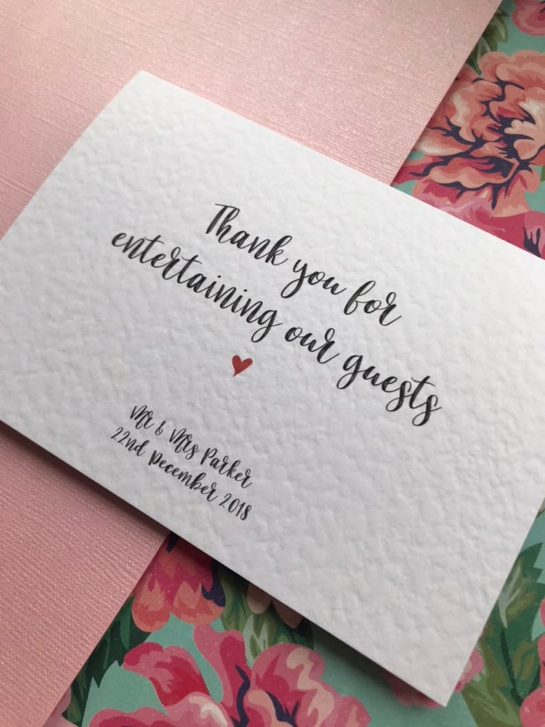 May include: White card with black calligraphy that reads "Thank you for entertaining our guests" with a small red heart. Below the text is "Mr & Mrs Parker 22nd December 2018".