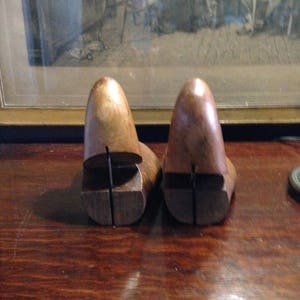 May include: Two wooden shoe trees, one brown and one dark brown, with a split design to help maintain the shape of shoes.