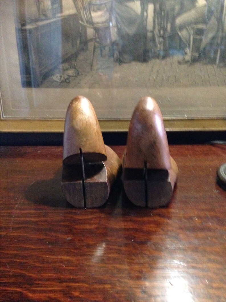May include: Two wooden shoe trees, one brown and one dark brown, with a split design to help maintain the shape of shoes.