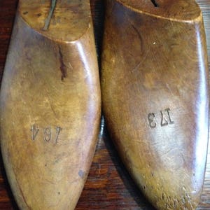 May include: Two wooden shoe lasts, one marked "7 1/4" and the other "12 3", used for shaping shoes.