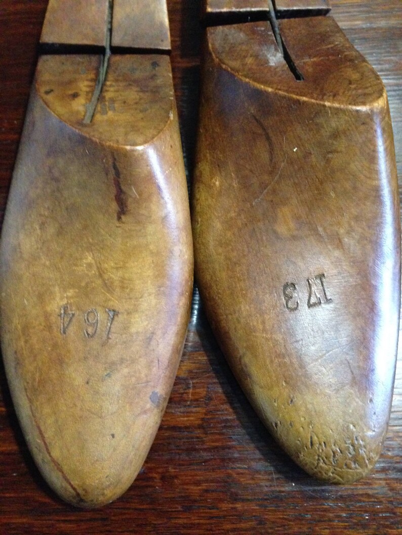 May include: Two wooden shoe lasts, one marked "7 1/4" and the other "12 3", used for shaping shoes.