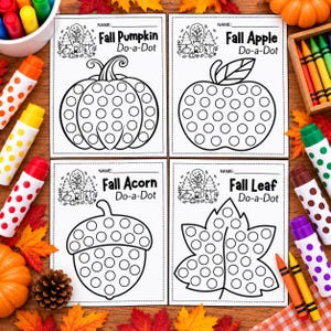 May include: Four white activity sheets with black outlines for dot markers, featuring a pumpkin, apple, acorn, and leaf. Each sheet includes the text Name, Do-a-Dot, and the object name. The sheets are surrounded by colorful markers and autumn decor.