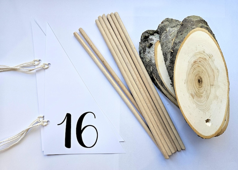 May include: White triangle pennant with the number 16 printed in black. The pennant has two white strings attached to the top corners. A bundle of wooden dowels and three wooden slices are also in the image.