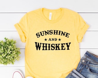 May include: Yellow t-shirt with black text that reads "Sunshine and Whiskey" with two stars between the words.