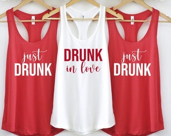 May include: Three tank tops with the text "just drunk", "drunk in love", and "just drunk" printed on them. The tank tops are red and white.