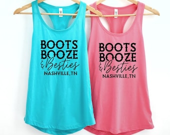 May include: Two tank tops with the text "Boots Booze & Besties Nashville, TN" printed on them. One tank top is turquoise blue and the other is pink.
