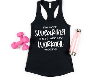 Puede incluir: Camiseta de tirantes negra con el texto "I'm not swearing these are my workout words" en blanco. Mancuernas rosas y una botella de agua rosa sobre un fondo blanco.