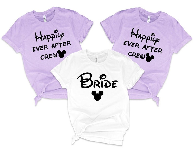 K&ouml;nnte beinhalten: Drei T-Shirts mit Disney-Motiv. Ein wei&szlig;es T-Shirt mit der Aufschrift "Bride" und einem Mickey-Maus-Kopf. Zwei lavendelfarbene T-Shirts mit der Aufschrift "Happily Ever After Crew" und einem Mickey-Maus-Kopf.