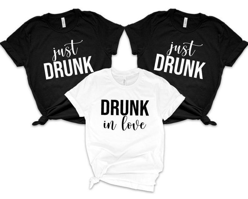 May include: Three t-shirts with the text "just drunk" on two black shirts and "drunk in love" on a white shirt.