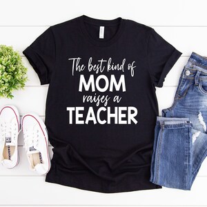 Puede incluir: Camiseta negra con texto blanco que dice "The best kind of MOM raises a TEACHER".