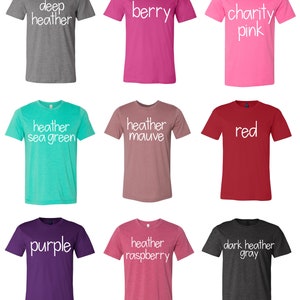 Puede incluir: Nueve camisetas de diferentes colores con distintos textos impresos en la parte delantera. Los colores son gris oscuro jaspeado, baya, rosa caridad, verde mar jaspeado, malva jaspeado, rojo, morado, frambuesa jaspeado y gris oscuro jaspeado. El texto en las camisetas incluye "gris oscuro jaspeado", "baya", "rosa caridad", "verde mar jaspeado", "malva jaspeado", "rojo", "morado", "frambuesa jaspeado" y "gris oscuro jaspeado".