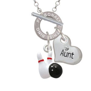 May include: Silver-toned necklace with a toggle clasp and a chain. The pendant features a bowling pin and ball charm, along with a heart-shaped charm that says "Aunt". The bowling pin is white with red stripes.