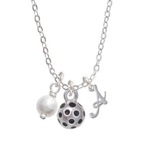 May include: A silver chain necklace with a pearl, a silver ball with black polka dots, and a silver charm with the letter 'A'.