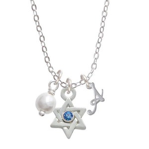 May include: A silver chain necklace with a silver Star of David pendant, a small pearl charm, and a silver letter 'A' charm. The Star of David has a blue gemstone in the center.