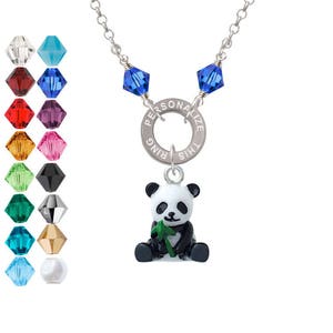May include: A silver necklace with a charm that says "Personalize This Ring" and a small panda bear charm holding a green bamboo shoot. The necklace has two blue crystal beads.