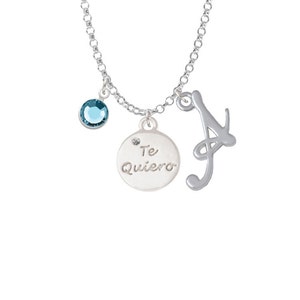 May include: Silver necklace with a charm that says "Te Quiero" and a letter A charm. The necklace also has a light blue crystal charm.
