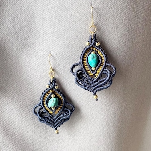 May include: A pair of blue and gold macrame earrings with turquoise stones. The earrings are made with a knotting technique and feature gold beads.