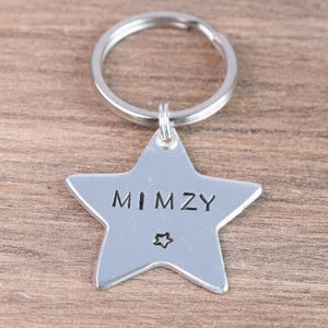 May include: Silver star-shaped keychain with the name "MIMZY" engraved on it.