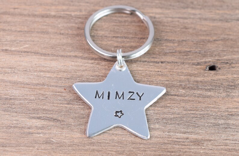 May include: Silver star-shaped keychain with the name "MIMZY" engraved on it.
