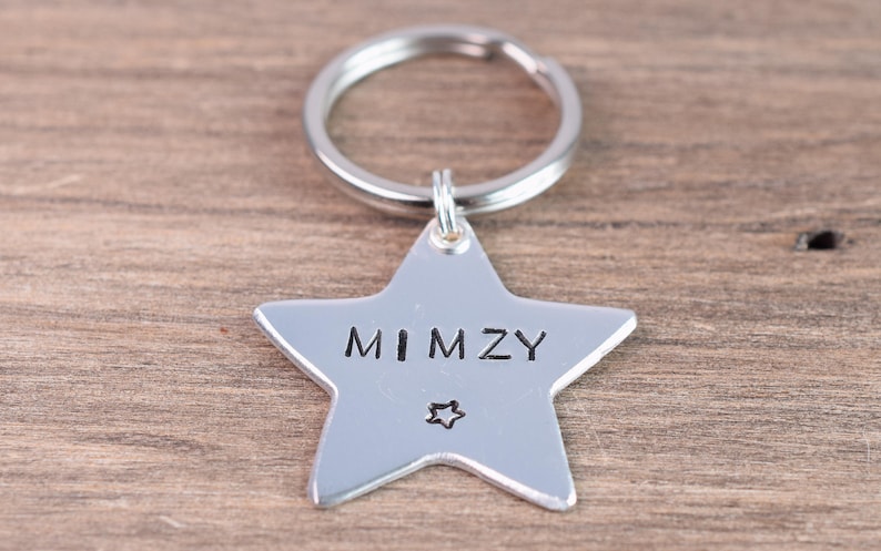 May include: Silver star-shaped keychain with a silver ring and the name "MIMZY" engraved on it.