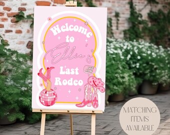 May include: Pink welcome sign with the text "Welcome to Ellie's Last Rodeo" with a disco ball, cowboy boots, and a cowboy hat. The sign is on an easel.