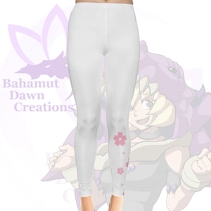 Op de afbeelding: Witte leggings met een roze bloemenpatroon op het linkerbeen. De leggings zijn tegen een achtergrond van een cartoonfiguur met paars haar en een roze en witte outfit.