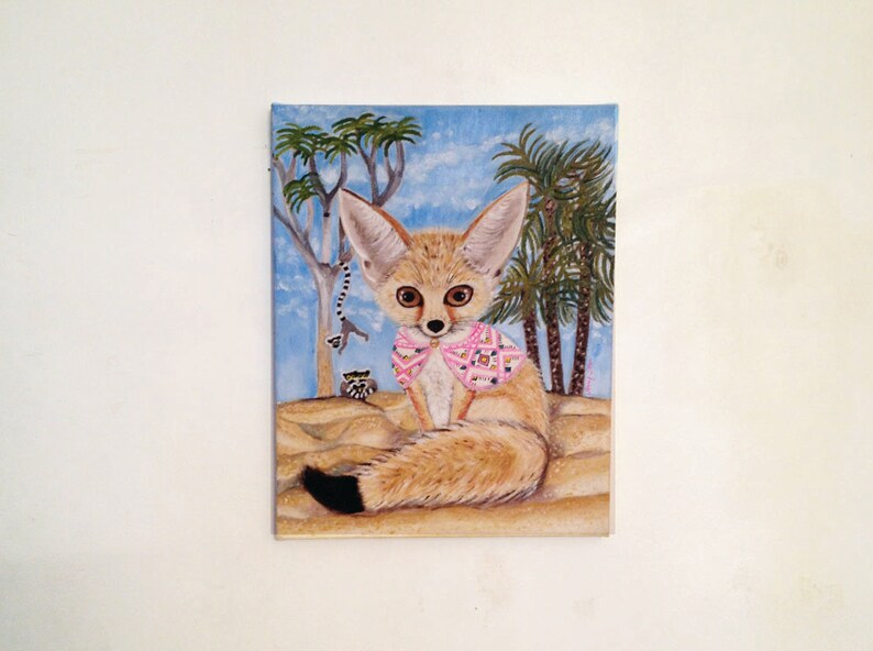 May include: A painting of a fennec fox wearing a pink and white patterned scarf. The fox is sitting in a desert scene with palm trees and a blue sky.
