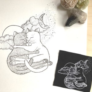 Peut inclure: Un dessin au trait noir et blanc de deux chats en train de se blottir sous un croissant de lune et des étoiles. Les chats sont dessinés avec une fourrure détaillée et se regardent.