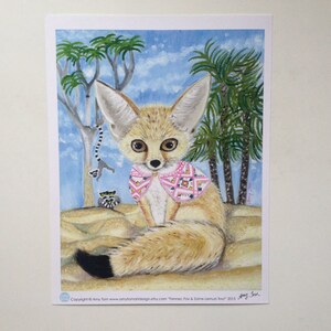 May include: A painting of a fennec fox wearing a pink and white patterned scarf. The fox is sitting on sand with palm trees in the background. The painting is signed "Amy Tom" and dated "2015".