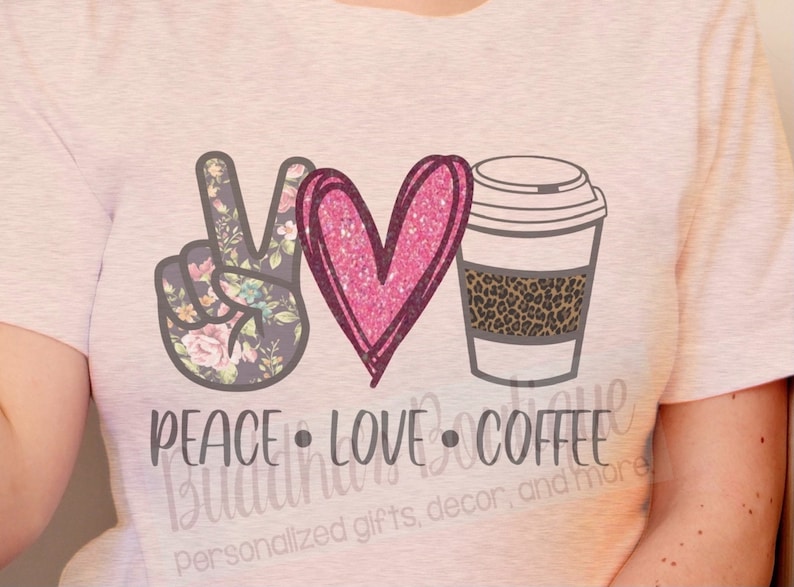May include: A pink t-shirt with a peace sign, heart, and coffee cup graphic. The peace sign is floral patterned, the heart is pink glitter, and the coffee cup has a leopard print band. The text "Peace Love Coffee" is below the graphic.