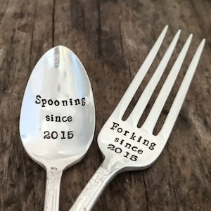 May include: A silver spoon and fork with the text "Spooning since 2015" and "Forking since 2015" engraved on them.