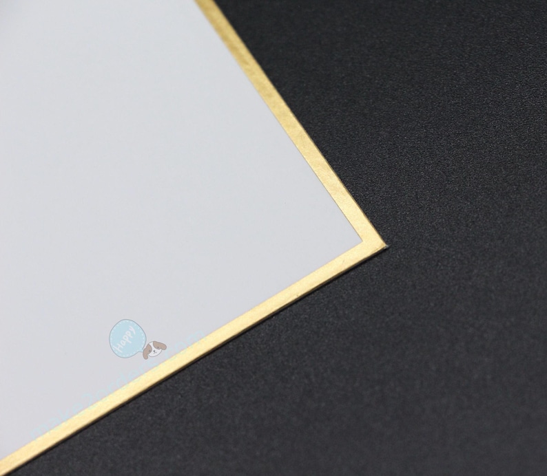 May include: A white card with a gold border and a small blue and brown graphic in the corner. The card is set against a black background.