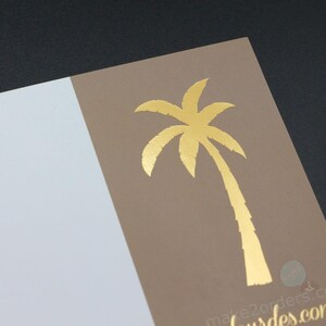 May include: A gold foil palm tree design on a tan card, with a white section on the left. The card is angled against a dark background. The website address "make2orders.com" is printed in gold at the bottom.