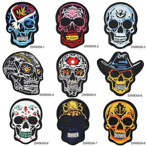 May include: Nine embroidered skull patches with diverse designs. Each patch showcases a skull with unique colour schemes and details, including cowboy hats and floral patterns. The patches are labelled with the code "DW9059-" followed by a number.