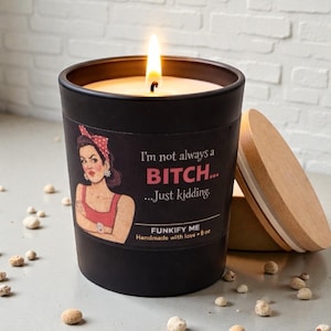 May include: A black candle with a lit wick, featuring a label with a retro woman illustration and the text "I'm not always a BITCH... Just kidding." The candle is handmade and weighs approximately 227 grams.