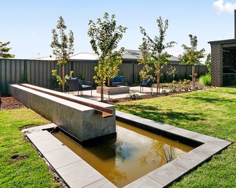 Concrete water feature wall - 10m with copper tap, draining into a black steel pond