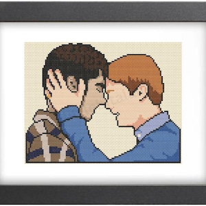 May include: Cross-stitch pattern of two men with brown hair, one wearing a blue shirt and the other wearing a plaid shirt, embracing each other.