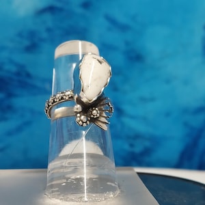 This ring is size 4 3/4 with a 6 x 15 mm Awesome White Buffalo Turquoise bordered by a leaves and blossoms,and a blossom band 1 of a kind