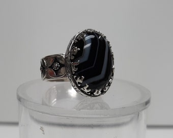 This men's ring is a Banded Agate 15 x 20mm size 12 3/4. It set in a NEW flame bezel and has been oxidized. Very Nice stone
