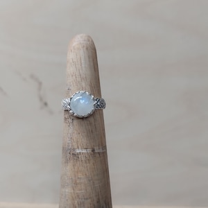Woman sterling silver ring size 3 1/4 with a 8 mm Rainbow Moon stone and a detailed band.